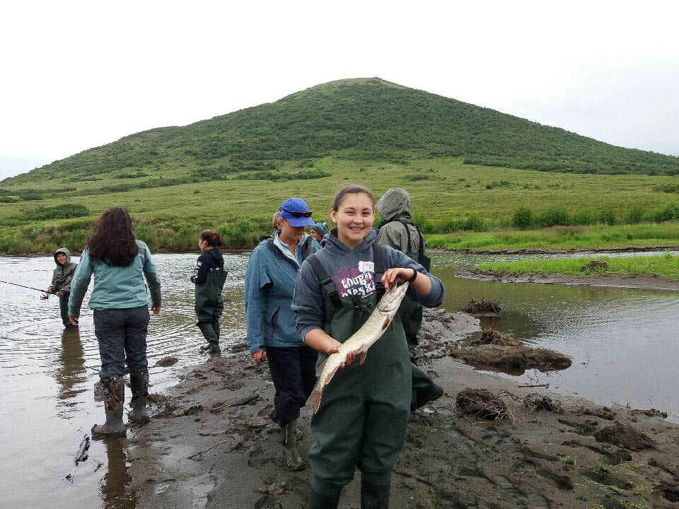 Student Andrea Lee shows a pike she caught July 17, 2017, during Orutsararmiut Native Council's Science and Culture Camp on the Kwethluk River and later, in Bethel, Alaska. (Photo by Paula Schiefer)