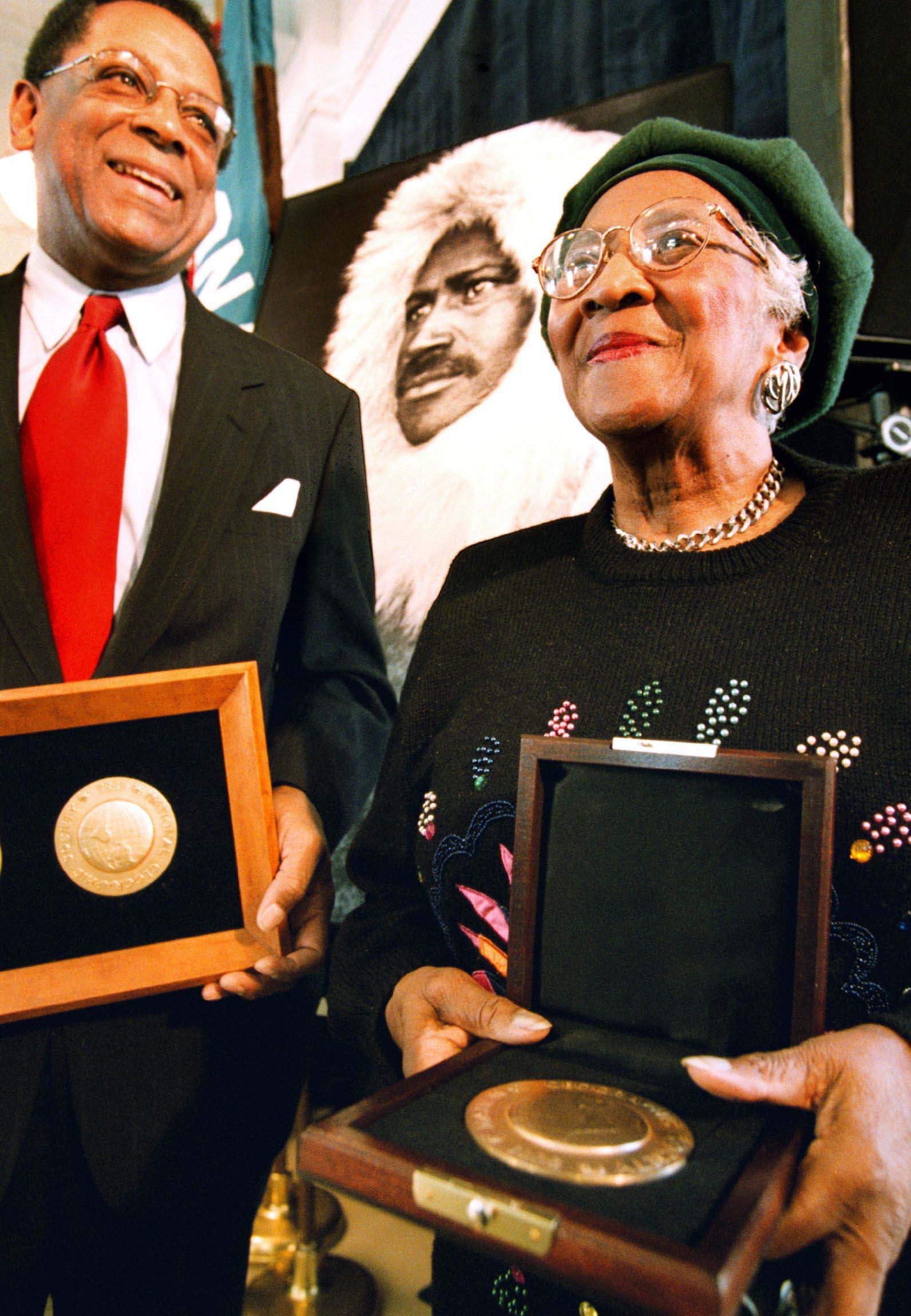 S. Allen Counter, left, with Audrey Mebane, a great-niece of polar explorer Matthew Henson, shown in the photo in the center. (Bill O'Leary / The Washington Post)